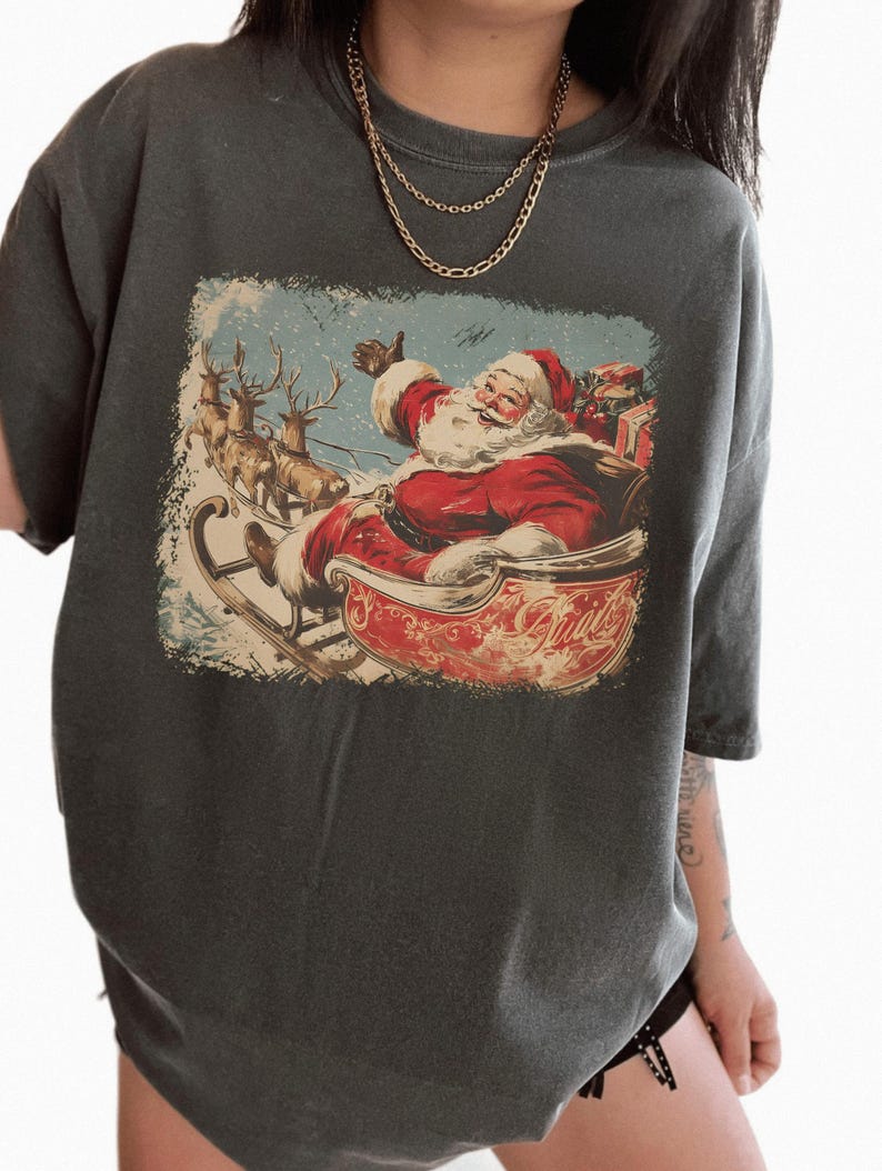 pepper dark-grey Christmas comfort colors shirt with vintage 60s Santa Claus riding sleigh and reindeer illustration; retro Santa Christmas tee, classic holiday t-shirt, cozy winter top, nostalgic Christmas graphic design, unisex festive crewneck, holiday gift idea, traditional Christmas aesthetic sweatshirt, matching family Christmas outfits sweater.