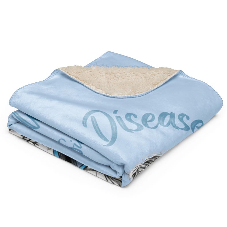 Pu&ograve; includere: Una coperta in pile sherpa azzurro piegata con un lato inferiore testurizzato color crema. La superficie superiore presenta una stampa grafica parziale con la parola Disease scritta in un carattere corsivo blu scuro e un'illustrazione in bianco e nero.