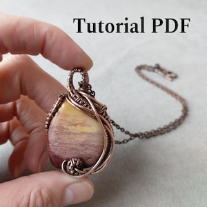 Puede incluir: Un colgante artesanal con un centro de piedra, envuelto en alambre de cobre. La piedra tiene una mezcla de tonos amarillos y morados. El colgante cuelga de una cadena de cobre. El texto "Tutorial PDF" es visible.