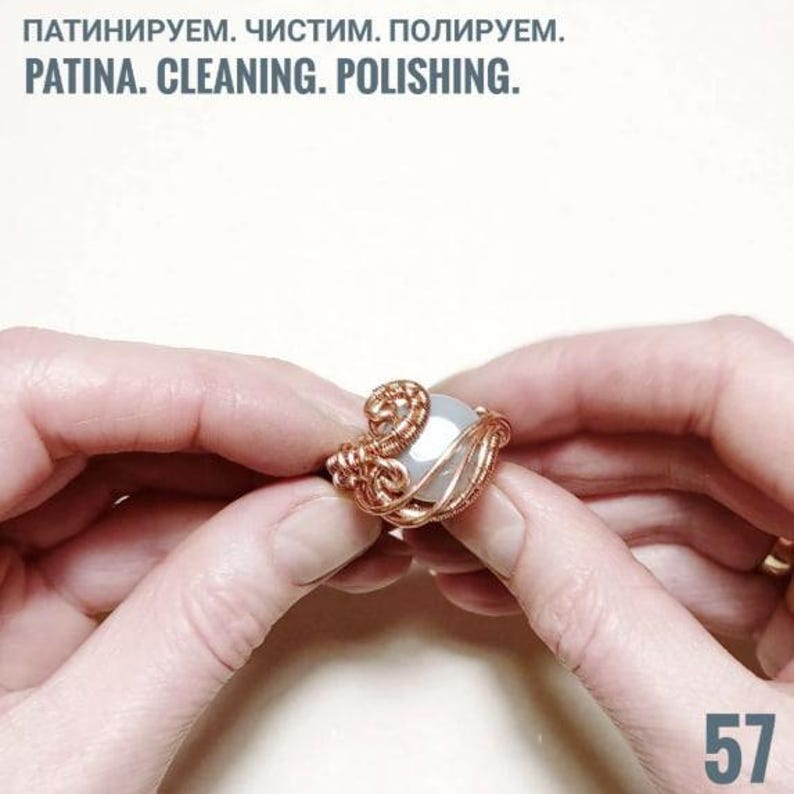 Peut inclure: Une bague en fil de cuivre faite &agrave; la main avec une pierre ronde de couleur claire. La bague est tenue entre deux mains. Le texte "PATINA. CLEANING. POLISHING." est en haut, et le num&eacute;ro "57" en bas &agrave; droite.