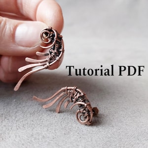 May include: Copper-colored wire-wrapped earrings with a unique, curved design. The earrings feature a spiral at the top and several downward-curving wires. The text "Tutorial PDF" is displayed in black.