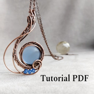 May include: A handcrafted copper wire pendant with a light blue stone center and three small blue beads. The pendant is suspended from a delicate chain. The text "Tutorial PDF" is displayed at the bottom.