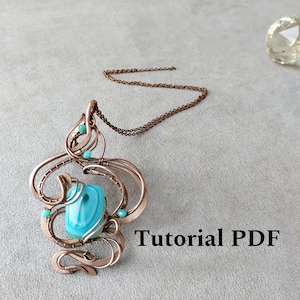 May include: A handcrafted copper wire pendant with a large, turquoise-colored stone at its center. The pendant features intricate wirework and small turquoise beads. The text "Tutorial PDF" is visible on the image. The pendant hangs from a copper chain.