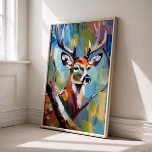 Könnte beinhalten: Ein gerahmter Kunstdruck mit einem farbenfrohen, impressionistischen Gemälde eines Hirsches. Das Kunstwerk zeigt den Kopf und das Geweih des Hirsches mit einer lebendigen Palette aus Blau-, Orange- und Grüntönen. Das Gemälde ist vor einem Hintergrund aus abstrakten Pinselstrichen.