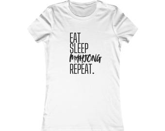 May include: White t-shirt with the text "EAT SLEEP MAHJONG REPEAT" in black, stylized font. The shirt has a crew neck and short sleeves. The text is centered on the front of the shirt.