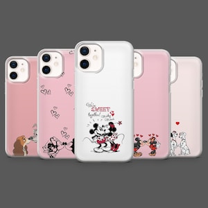 Op de afbeelding: Een verzameling telefoonhoesjes met verschillende ontwerpen. Eén hoesje is wit met Mickey en Minnie Mouse, de tekst "We're sweet together!" en hartjes. Andere hoesjes zijn roze met hartjes en stripfiguren.