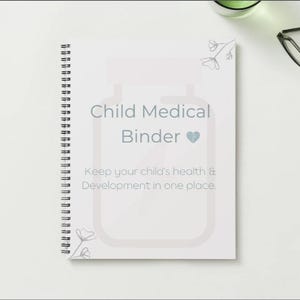 May include: A white spiral-bound notebook titled "Child Medical Binder" with a heart symbol. The text below reads "Keep your child's health & Development in one place." The notebook is on a white surface.