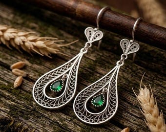 Pendientes artesanales de plata de ley con filigrana de esmeraldas en forma de lágrima.