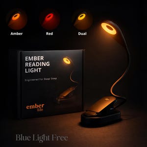 May include: A black reading light with a flexible neck and clip base. The light has three color settings: amber, red, and dual. The box reads "EMBER READING LIGHT" and "Engineered For Deep Sleep". The text "Blue Light Free" is also visible.