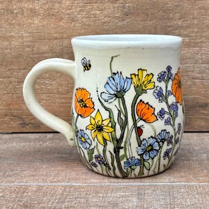 May include: A trio of ceramic mugs with a speckled, matte finish in cream, light grey, and dark grey. Each mug features a minimalist design and a rounded handle.