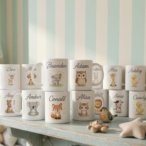 Puede incluir: Tazas de cerámica blanca con ilustraciones de animales y nombres personalizados. Las tazas presentan una variedad de animales, incluyendo un ciervo, un perro, un koala, un búho, un zorro, un gato, una jirafa, un pato y un oso. Nombres como Brandon, Adam y Ashley están impresos.