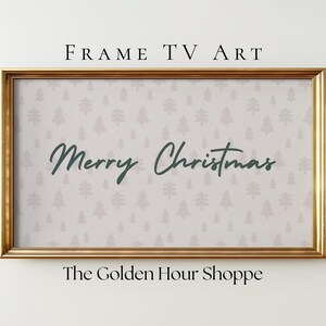 May include: A framed digital art piece for a TV screen. The artwork features a light gray background with a pattern of small, light gray Christmas trees. The words "Merry Christmas" are written in a dark green script. The frame is gold.