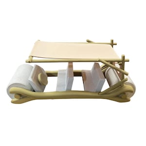 Puede incluir: Un modelo de coche caprichoso de estilo caricatura, con un toldo de lona beige y un marco de madera clara. El coche tiene asientos de piedra y un extremo delantero enrollado, evocando una estética prehistórica.