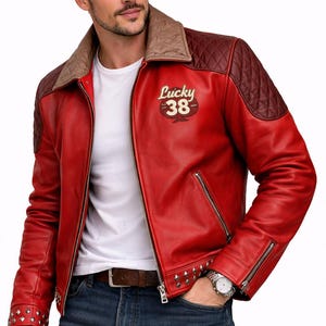 May include: A red leather jacket featuring a tan quilted collar, dark brown quilted shoulder panels, and silver metal studs along the hem and cuffs. The chest displays the text Lucky 38 in a cream-colored font above a spade graphic.