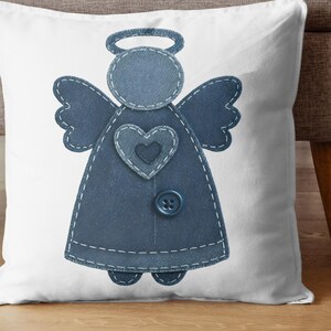 May include: White decorative pillow featuring a denim angel design. The angel has a halo, wings, and a heart-shaped detail. The design is stitched onto the pillow with a button accent. The pillow is placed on a wooden floor.