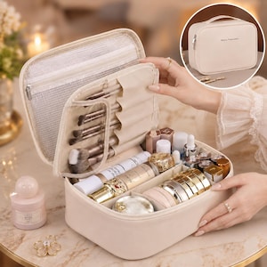 May include: A beige rectangular cosmetic travel case with a top handle and zipper closure. The interior features a mesh zippered pocket, elastic brush holders, and adjustable dividers containing various makeup bottles and compacts.