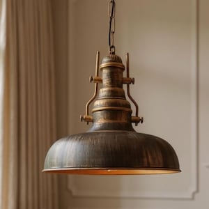 Puede incluir: Lámpara colgante de estilo vintage con acabado en bronce oscuro. La lámpara tiene una pantalla en forma de cúpula y está suspendida por una cadena. La lámpara emite un brillo cálido y acogedor, ideal para una cocina o comedor.