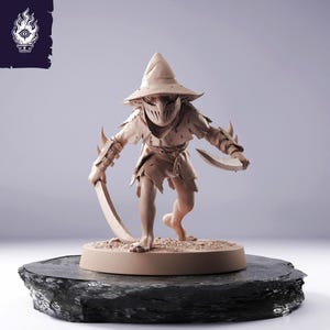 May include: A tan-coloured fantasy figurine of a masked warrior with a pointed hat and torn clothing, holding two curved blades. The figure stands on a round base atop a dark, textured surface. A logo is in the upper left corner.