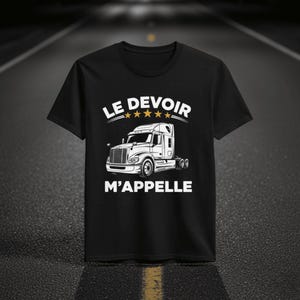 Puede incluir: Camiseta negra con una ilustración blanca de un camión. El texto "LE DEVOIR" está encima del camión, y "M'APPELLE" debajo. El diseño incluye cinco estrellas.