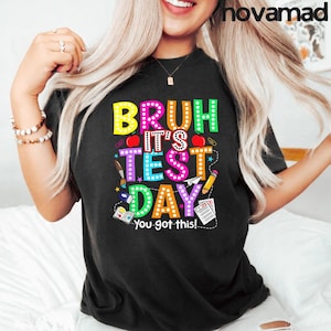 May include: A white ceramic mug with a black handle and the text "But First, Coffee" in a black, handwritten-style font. The mug is on a white surface.