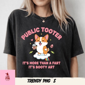 Könnte beinhalten: Dunkelgraues T-Shirt mit dem Text "PUBLIC TOOTER" über einem Cartoon-Corgi-Hund, der ein Getränk hält. Darunter steht der Text "IT'S MORE THAN A FART IT'S BOOTY ART". Das Design umfasst einen Regenbogen, Sterne und Süßigkeiten.