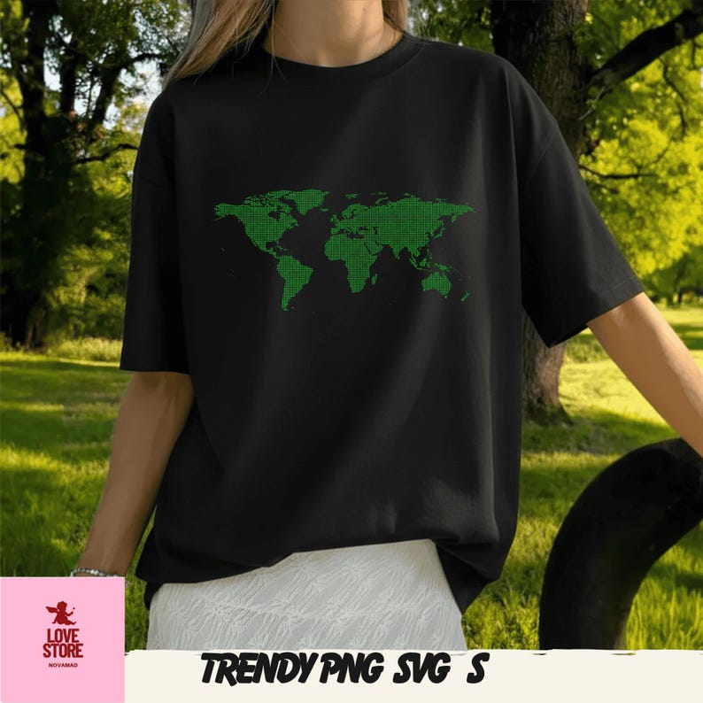 Op de afbeelding: Zwart T-shirt met een groen, gepixeld wereldkaartontwerp. Het shirt heeft korte mouwen en een ronde hals. De tekst "TRENDY PNG SVG S" staat onderaan de afbeelding.