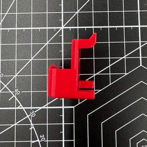 Side profile of the caliper holder on a measurement grid, showing the 12mm top opening and 15mm front-plate height.