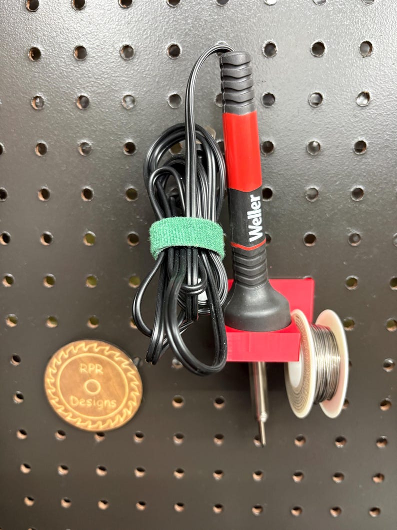 Red high-strength PETG soldering station mounted on a standard 1-inch pegboard showing a secure fit.