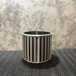 A professional silver and black two-tone desk organizer featuring a minimalist ribbed design for a sleek gaming or office aesthetic.