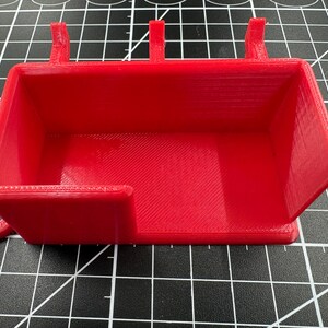 Front-facing view of the red holder showing the 39mm wide access cutout designed for easy tool grabbing and cable clearance.