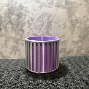 A futuristic silver and purple vertical-slotted desk accessory designed for designers and tech enthusiasts.