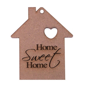May include: A wooden house-shaped ornament with a heart-shaped cutout and a hole for hanging. The words "Home Sweet Home" are engraved on the front. The ornament is a light brown color.