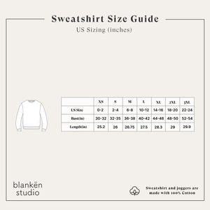 May include: A cream-colored graphic showing a sweatshirt size guide with US sizing in inches. The guide includes sizes XS to 3XL, with bust and length measurements. The text "Sweatshirt and joggers are made with 100% Cotton" is also present.