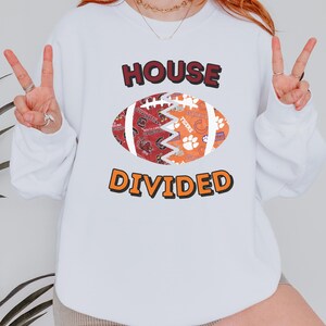 a woman wearing a white sweatshirt that says house divided
