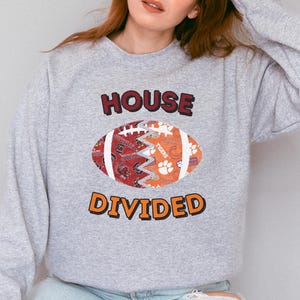 a woman wearing a sweatshirt that says house divided