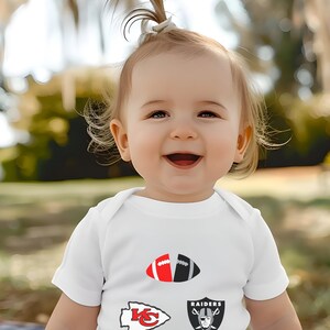 a baby girl wearing a white shirt with a football design on it