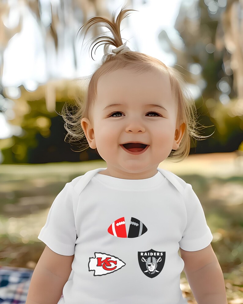 a baby girl wearing a white shirt with a football design on it