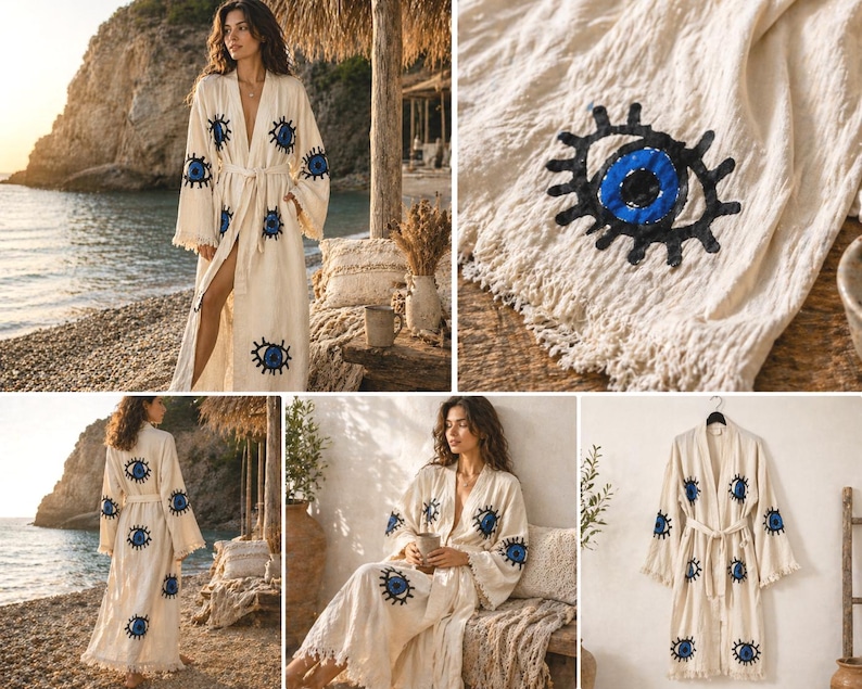 May include: A cream-colored robe with a belt and wide sleeves, adorned with embroidered blue and black eye motifs. The robe has a fringed hem and is made of a lightweight fabric. The robe is shown in multiple settings, including a beach and a room.