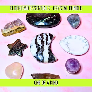 May include: A collection of various crystals and gemstones, including a star, a crescent moon, and a heart, arranged on a pink surface. The text "ELDER EMO ESSENTIALS - CRYSTAL BUNDLE" and "ONE OF A KIND" are displayed in the image.