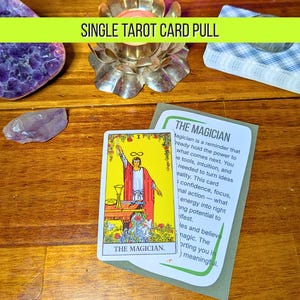 May include: A tarot card reading with the text "SINGLE TAROT CARD PULL" in a green banner. The card shows "THE MAGICIAN" with a figure in red and white robes. The card is on a wooden surface with crystals and a candle.