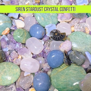 May include: A collection of colorful crystals and stones, including blue, green, purple, and clear varieties. The image features a variety of shapes and sizes, with the text "SIREN STARDUST CRYSTAL CONFETTI" in a green banner at the top.