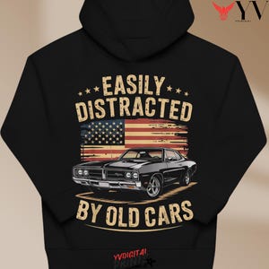 Peut inclure: Un sweat à capuche noir avec un graphisme d'une voiture noire classique, un drapeau américain et le texte "EASILY DISTRACTED BY OLD CARS". Le design comprend des étoiles et une esthétique vintage. Le sweat à capuche a une capuche à cordon.