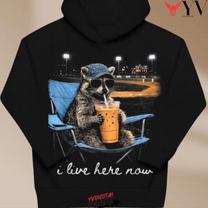 Funny Raccoon Ballfield Baseball Field I Live Here Now T-Shirt PNG, Raccoon Drinking Iced Coffee Mom Shirt Design