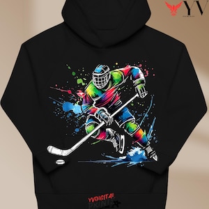 May include: Black hoodie with a colourful illustration of a hockey player in action. The design includes vibrant splashes of colour and a hockey puck. The hoodie has a drawstring hood and a kangaroo pocket.