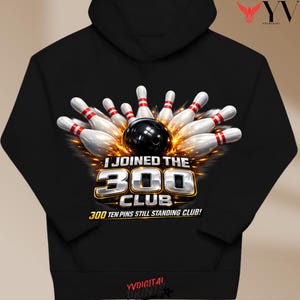Puede incluir: Sudadera con capucha negra con un diseño de bolos. Una bola de bolos negra está rodeada de bolos blancos y rojos con llamas. El texto dice "I JOINED THE 300 CLUB" y "300 TEN PINS STILL STANDING CLUB!".