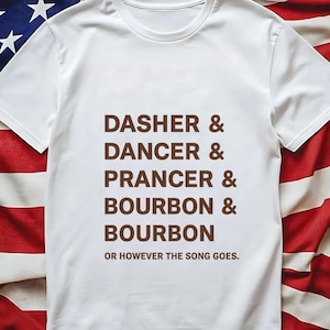 May include: White t-shirt with brown text listing "DASHER & DANCER & PRANCER & BOURBON & BOURBON" and the phrase "OR HOWEVER THE SONG GOES." The shirt is displayed against a backdrop of an American flag.