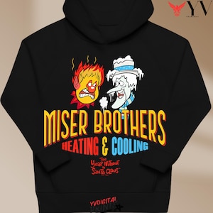 May include: A black hooded sweatshirt featuring a graphic of Heat Miser and Snow Miser. The text reads "Miser Brothers Heating & Cooling" in yellow, red, and blue, with "The Year Without a Santa Claus" printed below in red lettering.