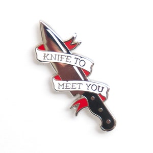 May include: Silver enamel pin with a knife and a banner that reads "Knife to meet you".