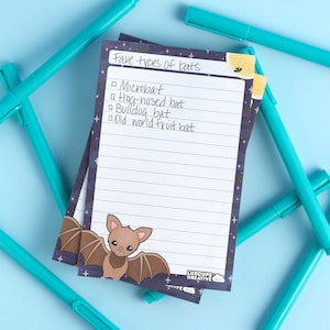 May include: A notepad with a dark blue background and white stars. The notepad has a list of "Fave types of bats" with the following types listed: Microbat, Hog-nosed bat, Bulldog bat, Old world fruit bat. The notepad has a cartoon brown bat on the bottom.