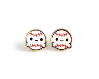 May include: A pair of gold-tone earrings featuring a white baseball with red stitching and a smiling face.